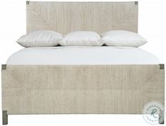 an upholstered bed with white linens and pillows