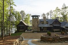 a large stone house surrounded by trees and water