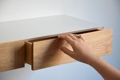 a person's hand is holding onto a drawer