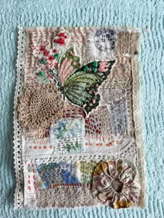 a piece of cloth with various patches and flowers on it sitting on top of a blue blanket