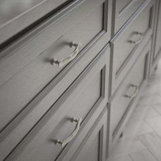 a large gray dresser with chrome handles and knobs on it's drawers in a bathroom