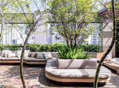 an outdoor living area with couches and trees