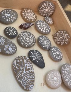 some rocks are sitting in a box on the floor and one is decorated with snowflakes