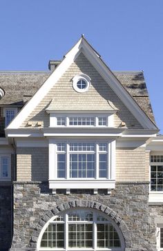 a large stone house with white trim and windows