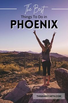 a woman standing on top of a rock in the desert with her arms raised up