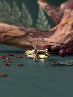 Now you can be the Queen of Terrasen with the tiny and dainty Goldryn sword wrapped around your finger as a ring. Made of solid brass plated 18k Gold the ring comes in the shape of the Aelin's Goldryn sword with a shiny and bright red ruby crystal casted in the pommel of the sword. The ring is really detailed as you can see from the pictures. Details of the object: Material: Brass Colour: Gold Size: 5US - 6US - 7US - 8US - 9US From THRONE OF GLASS, by Sarah J. Maas, ©2012. Created with permission of Writers House LLC acting as agent for the author. Queen Of Terrasen, Book Ring, Book Rings, Aelin Galathynius, Ruby Crystal, Throne Of Glass, Red Ruby, Brass Color, Glass Jewelry