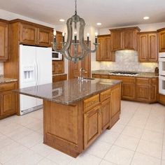 a large kitchen with wooden cabinets and granite counter tops