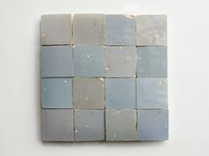 a white and blue tile wall hanging on the wall