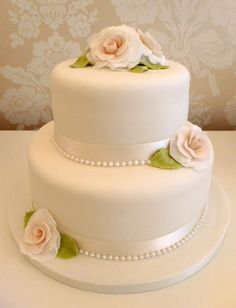 a three tiered white cake with flowers on top