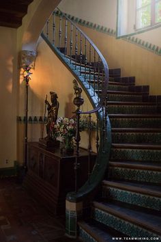 the stairs are made of wood and have intricate designs on them, along with decorative vases