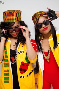 two women in yellow jackets and red pants are posing for the camera with their hands on their faces