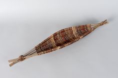 an object made out of woven material on a white surface with two sticks sticking out of it