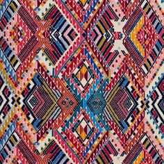 an old colorful rug with many different colors and patterns on the surface, including red, blue