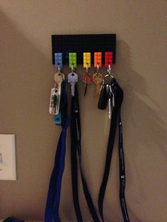 several keys are hanging on a wall with lanyards attached to it and two key holders in the middle