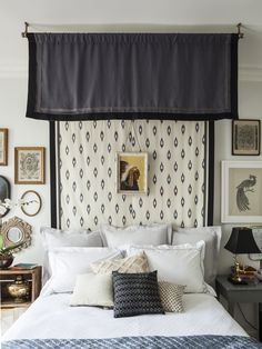 a bed with pillows and pictures on the wall above it, along with other decorations