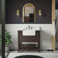 a white sink sitting under a mirror in a bathroom next to a black and white rug