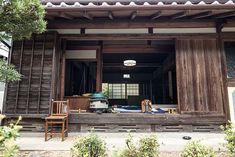 an outside view of a wooden building with two chairs and a table in the window