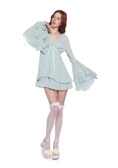 Be heavenly in this chiffon mini dress which has tiered bell sleeves, interlocking ribbon detailing, a ruffled trim, a plunging neckline, a cross charm on the front, and a tiered skirt. Bell Sleeve Mini Dress, Doll Skirt, Flowy Mini Dress With Bell Sleeves And Ruffle Hem, Chiffon Mini Ruffle Dress With Ruffle Hem, Feminine V-neck Chiffon Dress With Ruffles, Feminine Chiffon V-neck Dress With Ruffles, Chiffon Ruffle Dress With Mini Length, Bell Sleeves Dress, Feminine Chiffon Ruffled V-neck Dress