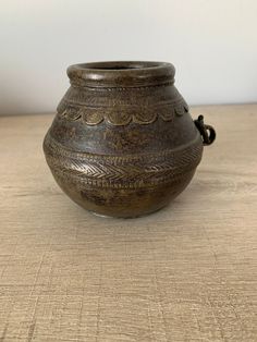 a brown vase sitting on top of a wooden table