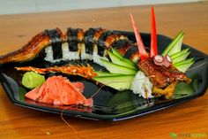 a black plate topped with different types of sushi