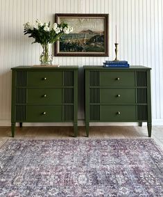 two green dressers sitting on top of a rug in front of a framed painting