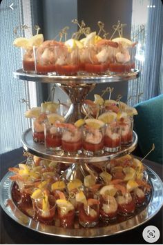 a three tiered tray filled with cupcakes covered in sauce and toppings