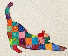 a colorful cat made out of patchwork on a quilted wallhange with white background