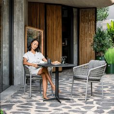 a woman sitting at a table in front of a building