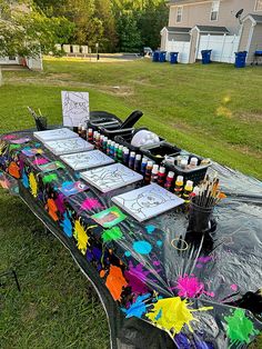 the table is covered with art supplies and has been set up for an outdoor event