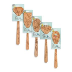 four wooden spatulas with pictures of people on them