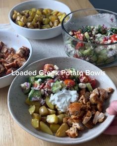 three bowls filled with different types of food on top of a wooden table next to a person's hand