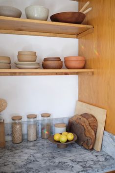 the shelves are filled with bowls, plates and other kitchen ware on it's sides