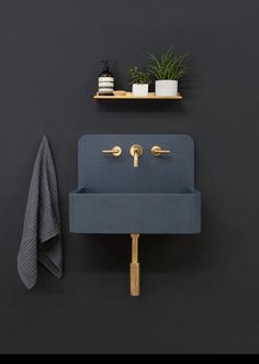 a blue sink sitting on top of a wooden shelf next to a potted plant