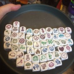 a person holding a plate with several dices in the shape of letters on them