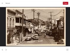 an old black and white photo of cars driving down the street