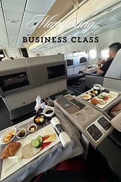 an airplane cabin with two trays of food on the table