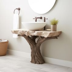 a bathroom with a tree stump sink and round mirror on the wall, next to a towel rack