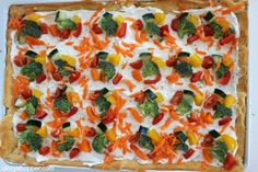 an uncooked pizza with vegetables and cheese on top is ready to be eaten