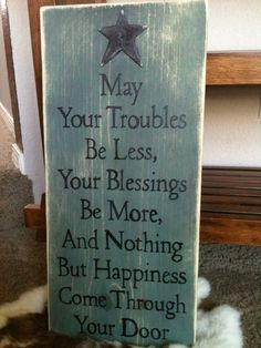 a sign that says may your troubles be less, your blessing be more and nothing but happiness come through your door