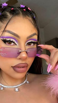 a woman with pink makeup and purple eyeliners is posing for the camera while wearing sunglasses