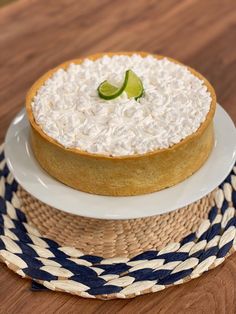 a cake on a plate sitting on top of a woven place mat next to a basket