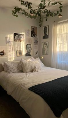 a bed with white sheets and pillows in a bedroom next to pictures on the wall