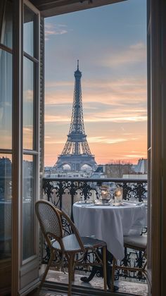 the eiffel tower is seen through an open window in this room with tables and chairs