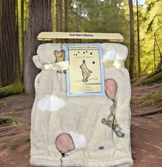 a polar bear blanket hanging from a tree in the woods with an ad on it