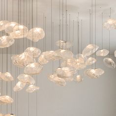 a group of lights hanging from the ceiling in a room with white walls and flooring