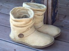 a pair of brown boots sitting on top of a wooden floor next to a door