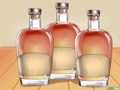 three bottles of liquor sitting on top of a wooden table