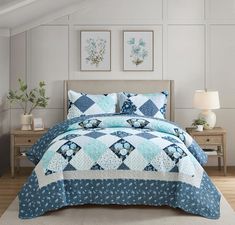 a bed with blue and white quilts in a room