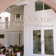 the entrance to lucky you yoga studio with lots of people doing exercises in the background