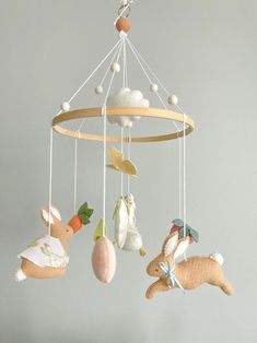 several stuffed animals are hanging from a wooden mobile in the shape of a baby's crib